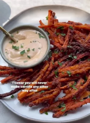 Bowl of crispy carrot fries garnished with herbs.