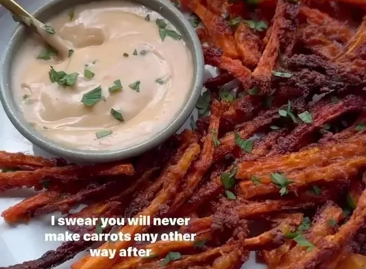 Bowl of crispy carrot fries garnished with herbs.