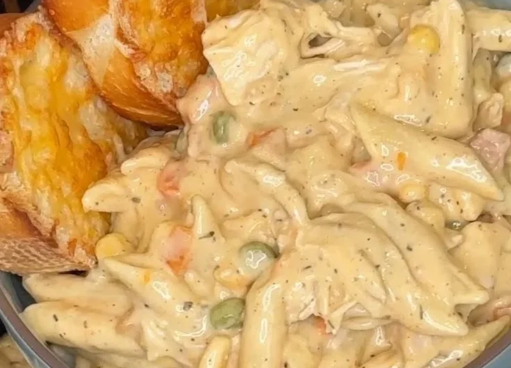 Crock Pot Chicken Pot Pie Pasta served in a bowl with herbs on top.