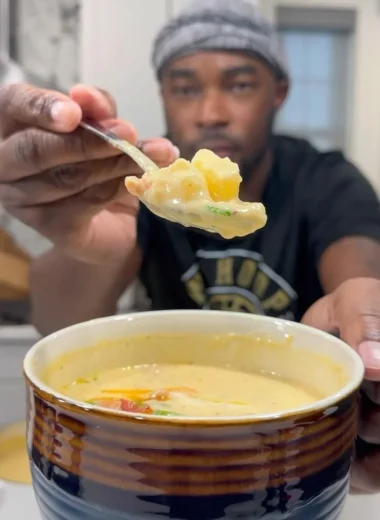 Bowl of creamy loaded potato soup topped with cheese and green onions