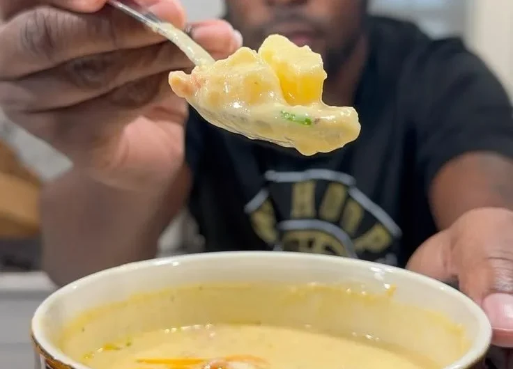 Bowl of creamy loaded potato soup topped with cheese and green onions