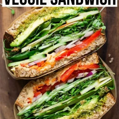 A colorful veggie sandwich filled with fresh vegetables and herbs.