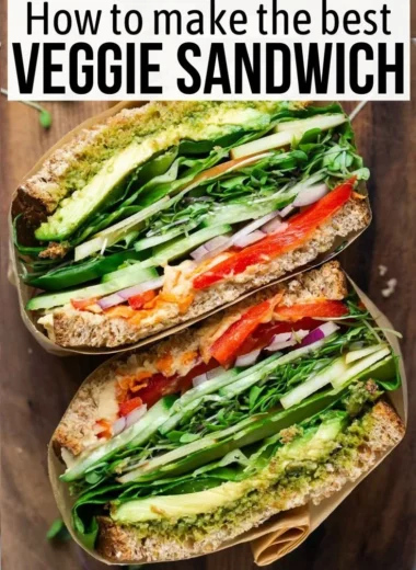 A colorful veggie sandwich filled with fresh vegetables and herbs.