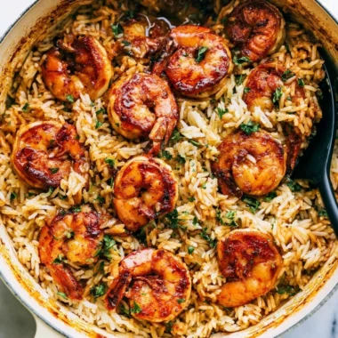 Cajun shrimp served over rice with vibrant veggies and spices.