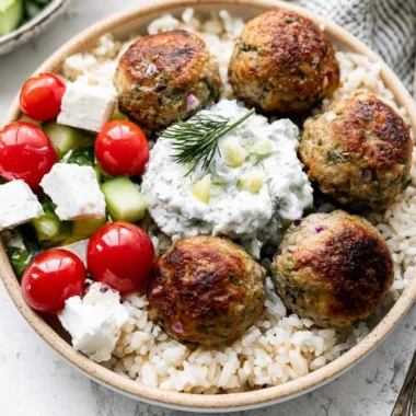 Plate of Greek Turkey Meatballs garnished with herbs and served with dipping sauce.