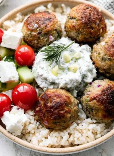 Plate of Greek Turkey Meatballs garnished with herbs and served with dipping sauce.