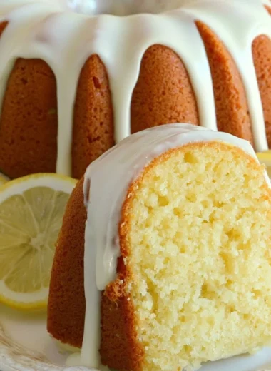 Slice of Italian lemon pound cake on a white plate with a lemon garnish.