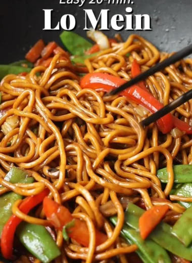 A bowl of Lo Mein noodles topped with colorful vegetables and savory sauce.