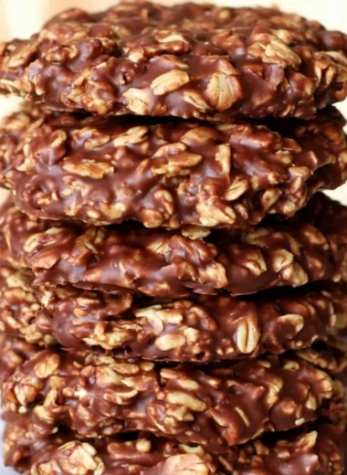 No bake chocolate oatmeal cookies on a plate, topped with chocolate drizzle.