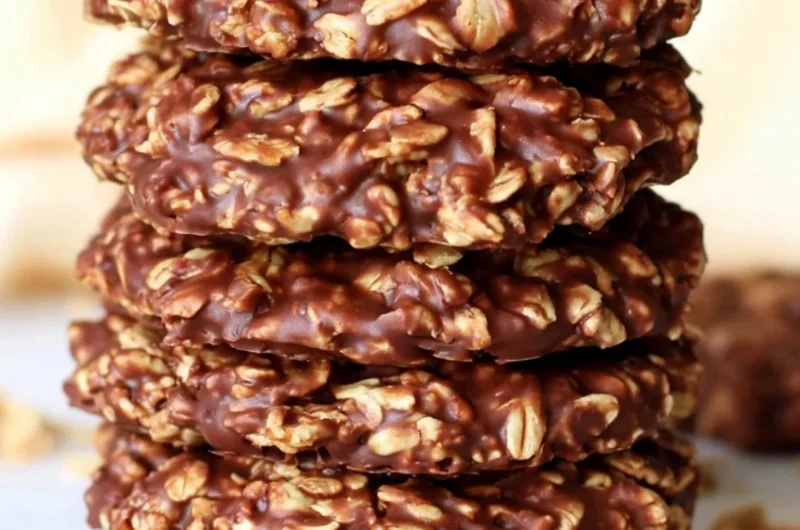 No bake chocolate oatmeal cookies on a plate, topped with chocolate drizzle.