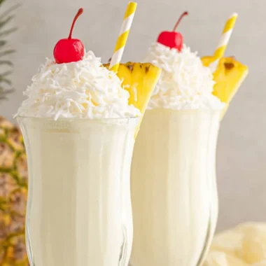 Delicious Pina Colada Milkshake topped with whipped cream and pineapple.