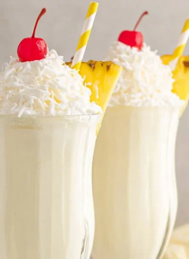 Delicious Pina Colada Milkshake topped with whipped cream and pineapple.
