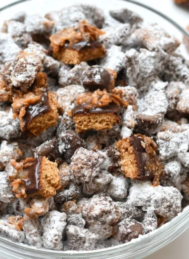 A delicious bowl of Samoas Puppy Chow with chocolate and coconut toppings.