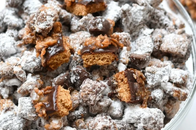 A delicious bowl of Samoas Puppy Chow with chocolate and coconut toppings.