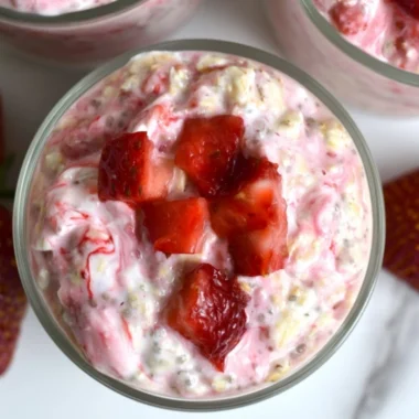 Bowl of strawberries and cream overnight oats topped with fresh strawberries