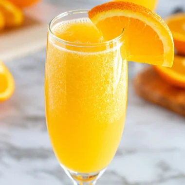 Freshly made non-alcoholic mimosa served in a glass with orange slices.
