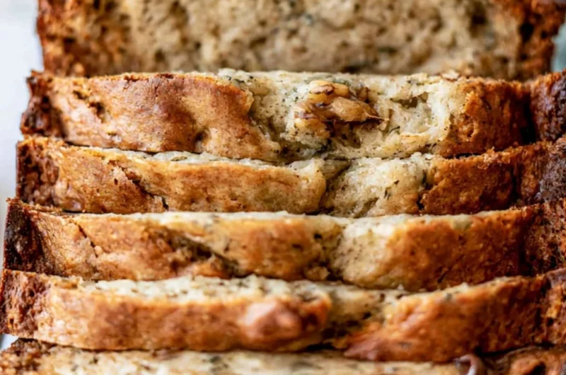 Sliced easy banana bread on a wooden cutting board