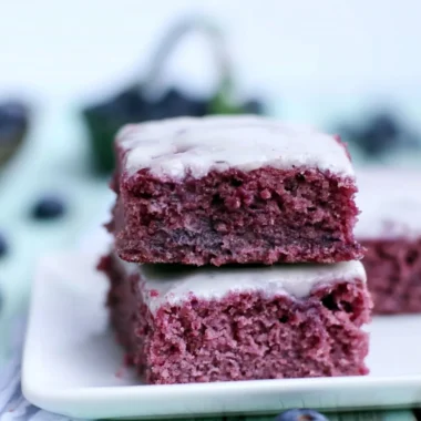 Delicious cozy glazed blueberry brownies with fresh blueberries on top