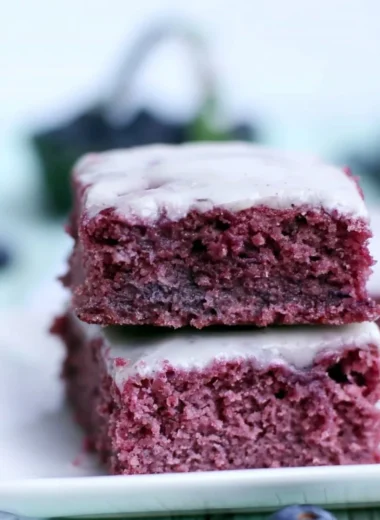 Delicious cozy glazed blueberry brownies with fresh blueberries on top
