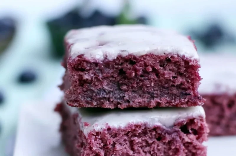 Delicious cozy glazed blueberry brownies with fresh blueberries on top