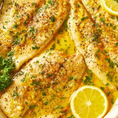 Cozy oven baked tilapia dish served with fresh herbs and lemon