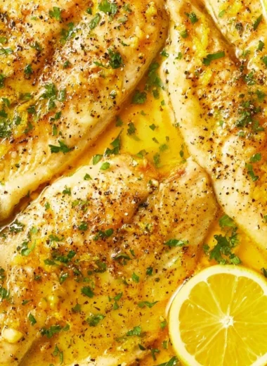 Cozy oven baked tilapia dish served with fresh herbs and lemon