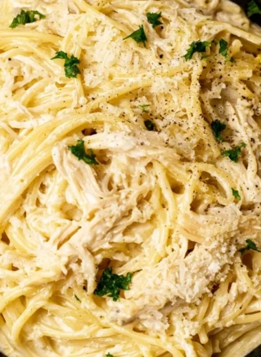 Creamy lemon chicken pasta served on a plate with fresh herbs and lemon slices