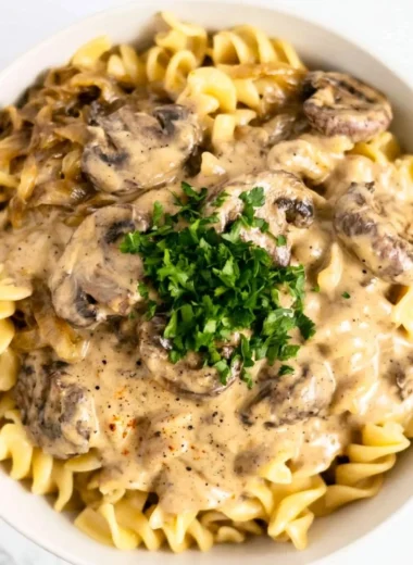Creamy vegetarian mushroom stroganoff served in a bowl with fresh herbs.