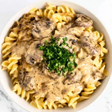 Creamy vegetarian mushroom stroganoff served in a bowl with herbs