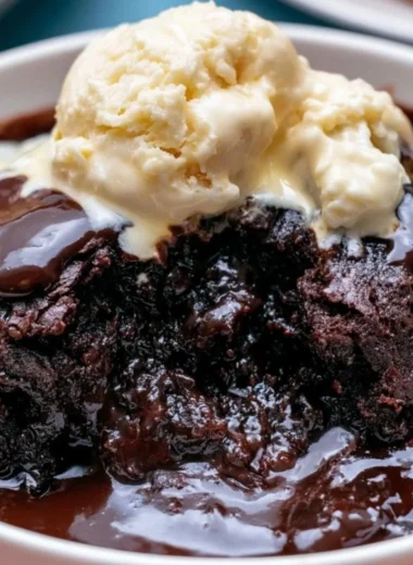 Delicious Crockpot pudding brownies in a dish, topped with chocolate drizzle.