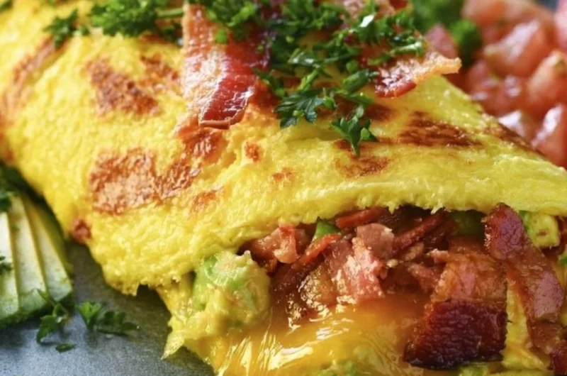 Keto avocado and bacon stuffed omelette served on a plate