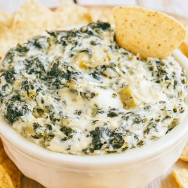 Creamy slow cooker spinach artichoke dip served with tortilla chips