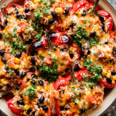 Plate of colorful vegetarian stuffed peppers filled with grains and vegetables