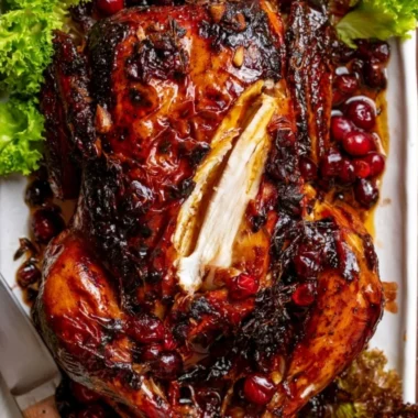 Cozy whole roast chicken with cranberry-maple glaze served on a wooden table